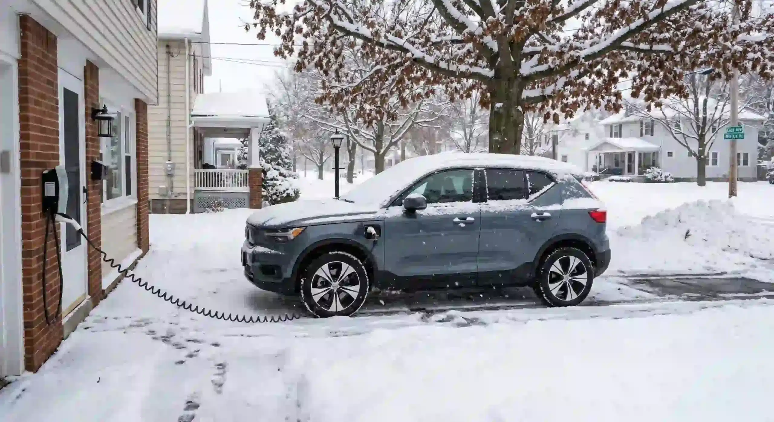 Electric vehicle charging in a snowy Rochester driveway on a Level 2 home charger